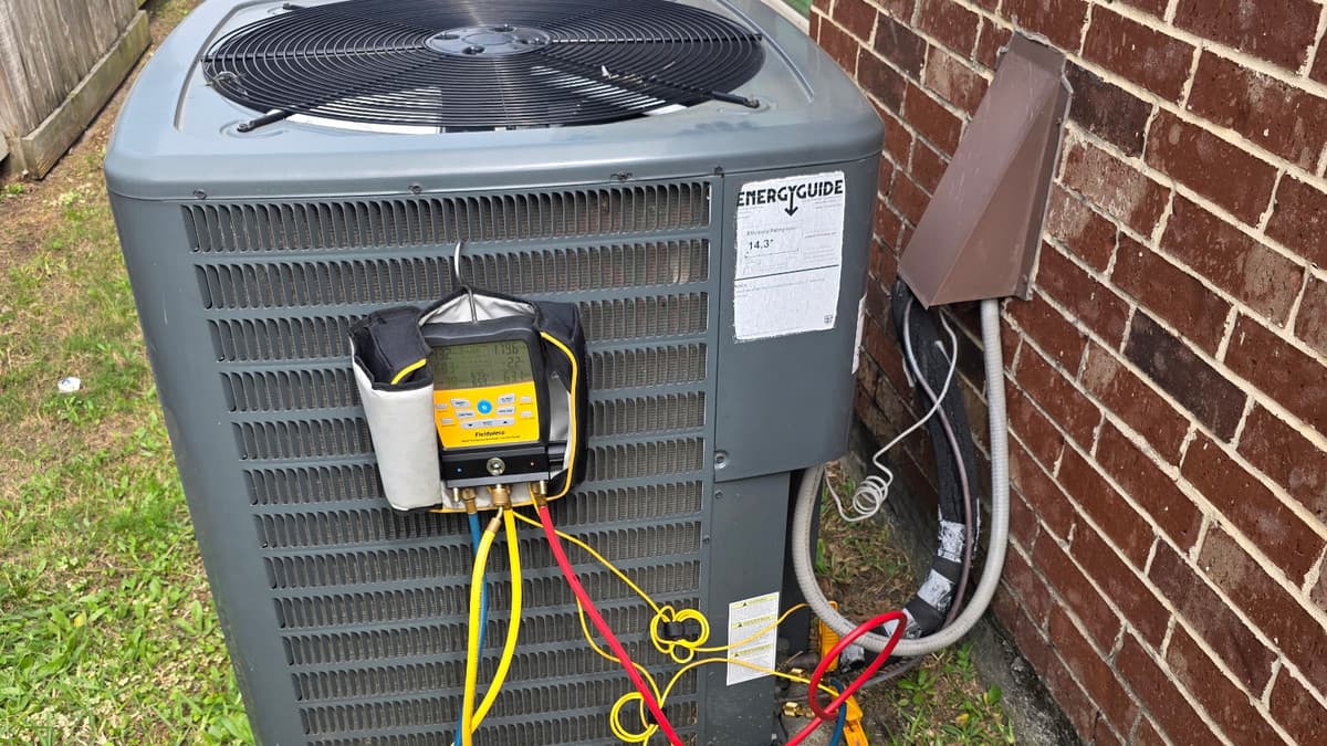 Refrigerant manifold gauges connected to an outdoor condensing unit during a diagnostic